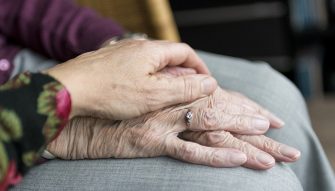 main posée sur les mains d'une personne âgée